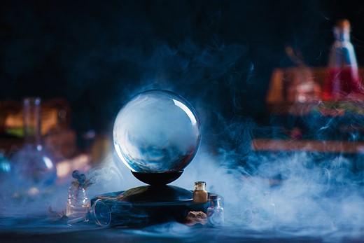 a crystal ball poised on a smokey plinth