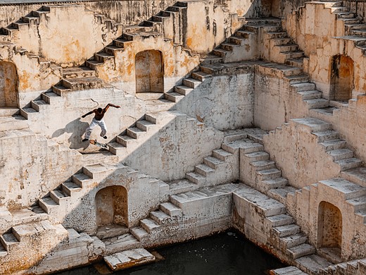 a person skateboards amidst a wall of stairs and doorways