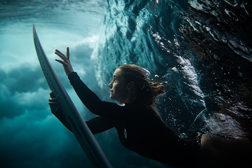 a surfer dives under a wave with their board