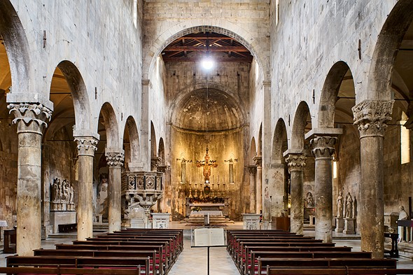 wooden pews are lined up in an old roman church