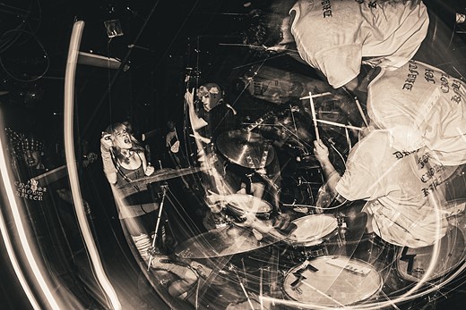 a drummer and other musicians blur in a confusing swirl of motin