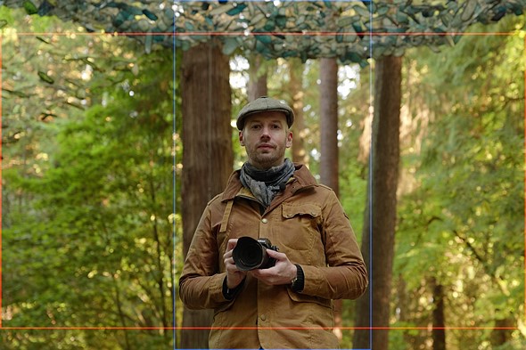 man standing under glass scupltures with horizontal and vertical frame lines