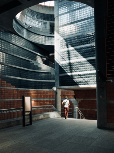 A person walking through a modern curved architectural interior, placed along a lower third as one of many rule of thirds examples in architectural photography.