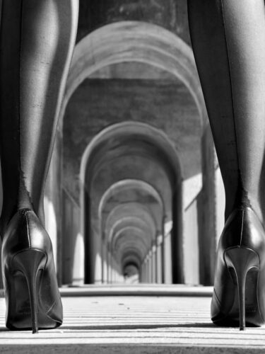 A spiral staircase photographed from above creates a circular frame within a frame, showcasing framing techniques in black and white architecture photography.