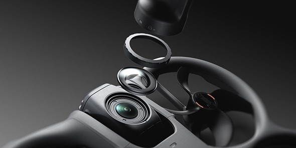 Interchangeable lenses float in pieces above a gray drone with a gray background