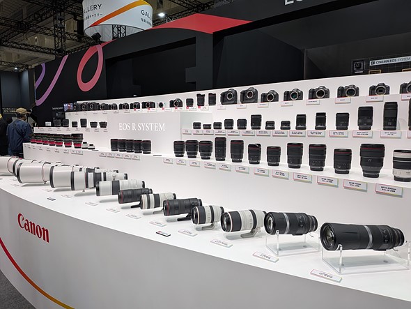 white shelves are lined with canon cameras and lenses