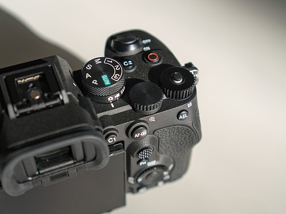 a black camera sits on aa white table with strong directional light