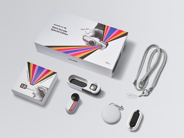 a white camera and accessories are laid out in a grid next to packaging