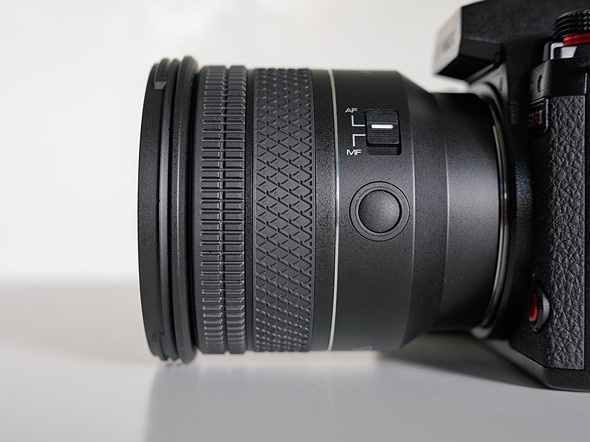a lens attached to a camera is on a white table with white background