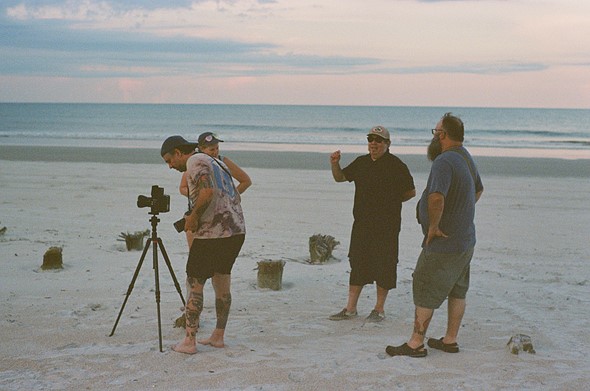 a small group of people gather on a beach