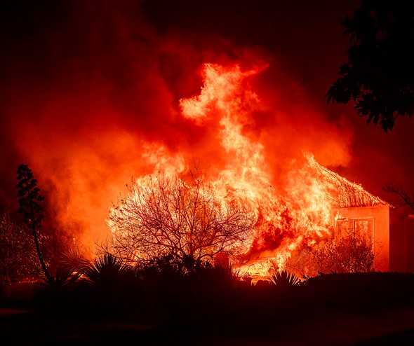 flames engulf a structure with smoke filling the night sky
