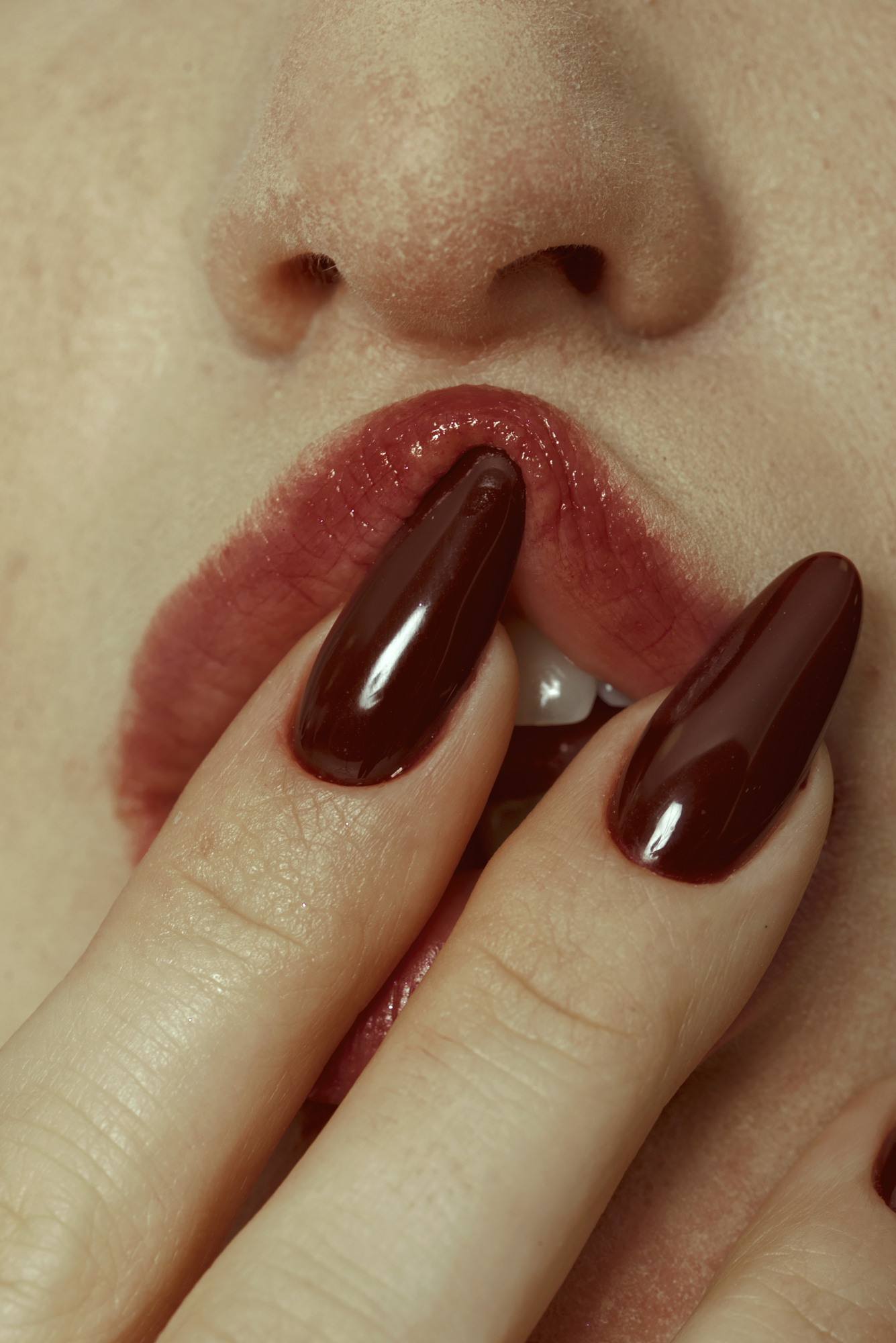 Macro fine art fashion detail featuring glossy deep-red nails and lips captured by Micaela Belgiorno photography.