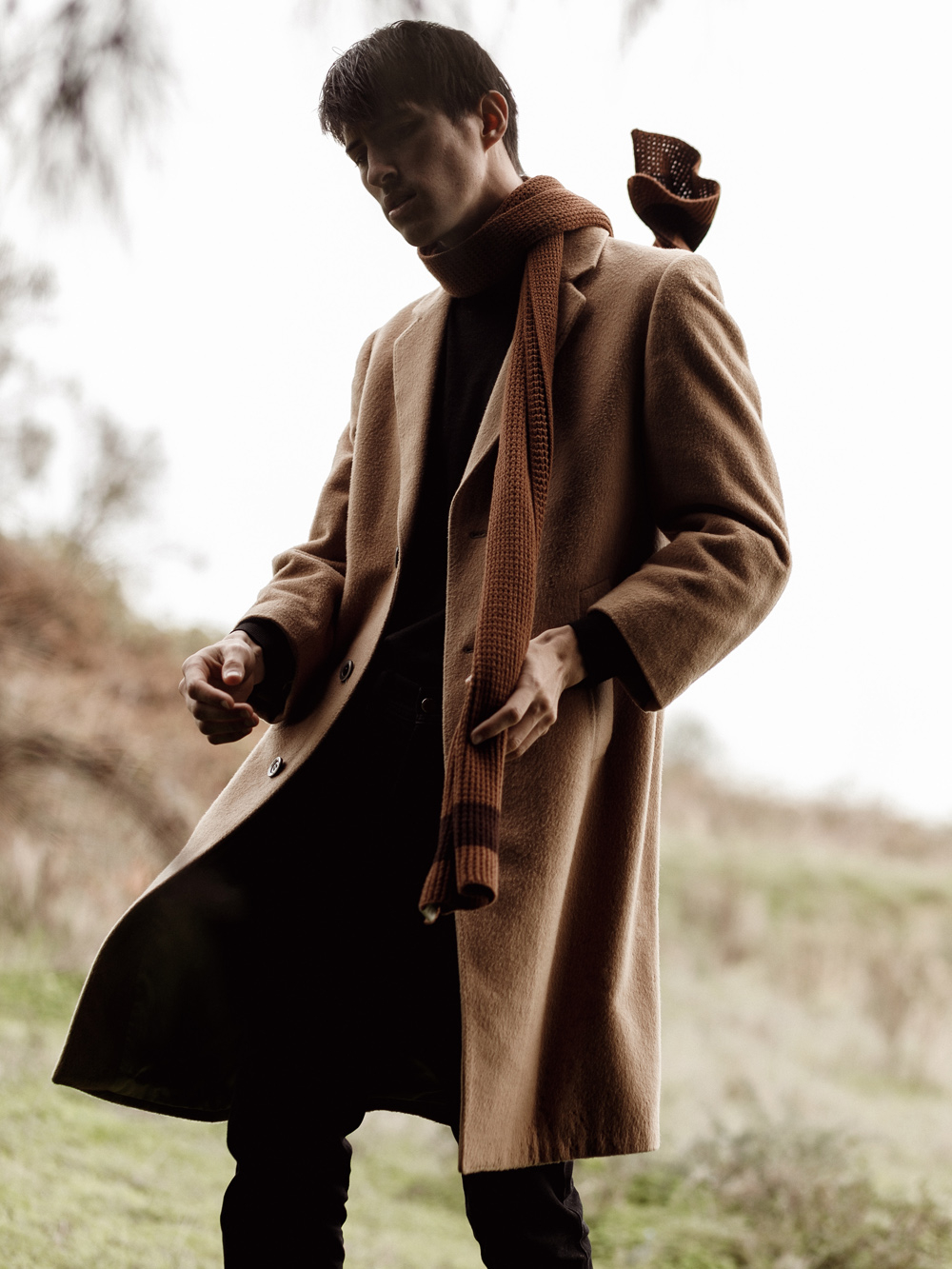 Outdoor male fashion photography portrait of a model wearing a classic brown overcoat and knit scarf by David Velez photography.