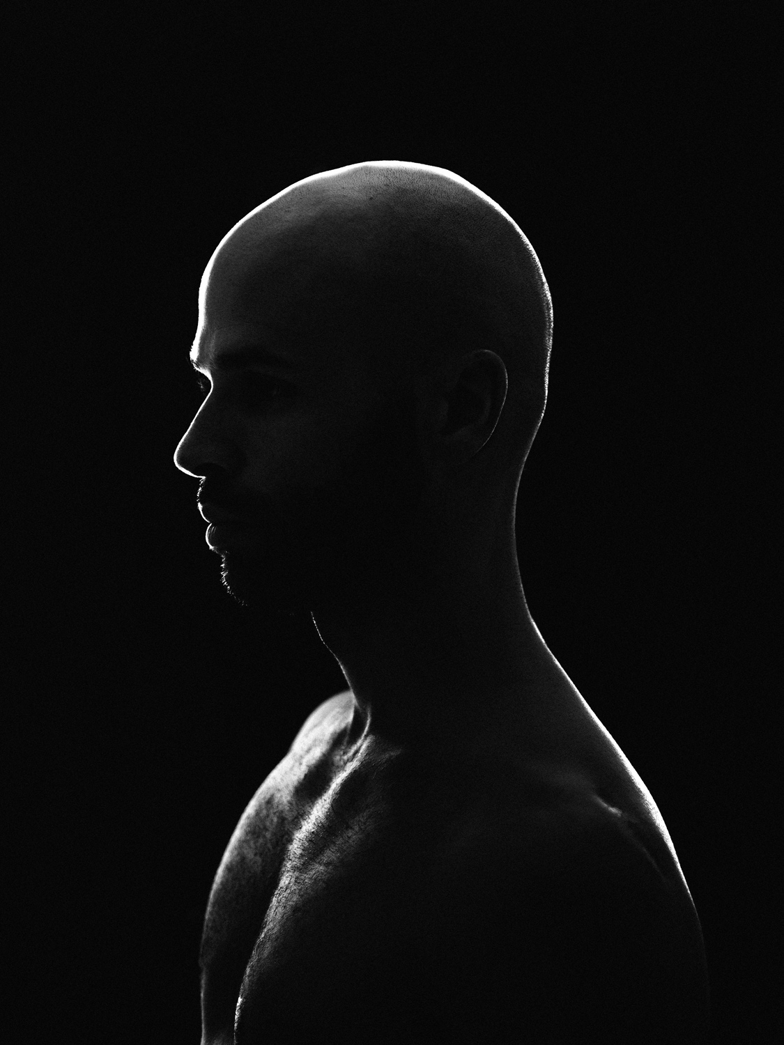 Dramatic black and white profile portrait utilizing intense studio rim lighting, captured by David Velez photography.