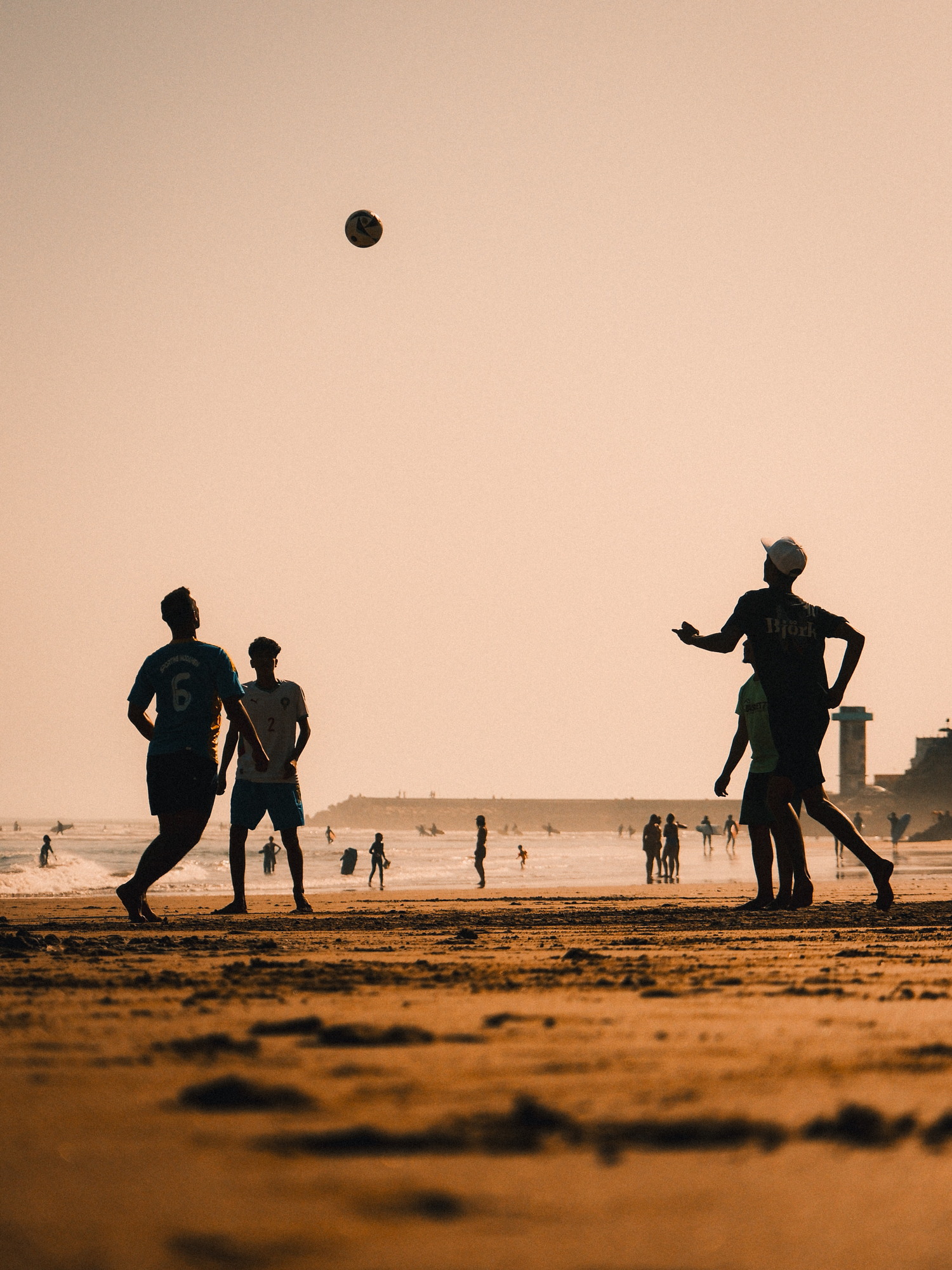Silhouettes of a beach football game at sunset on the Moroccan coast