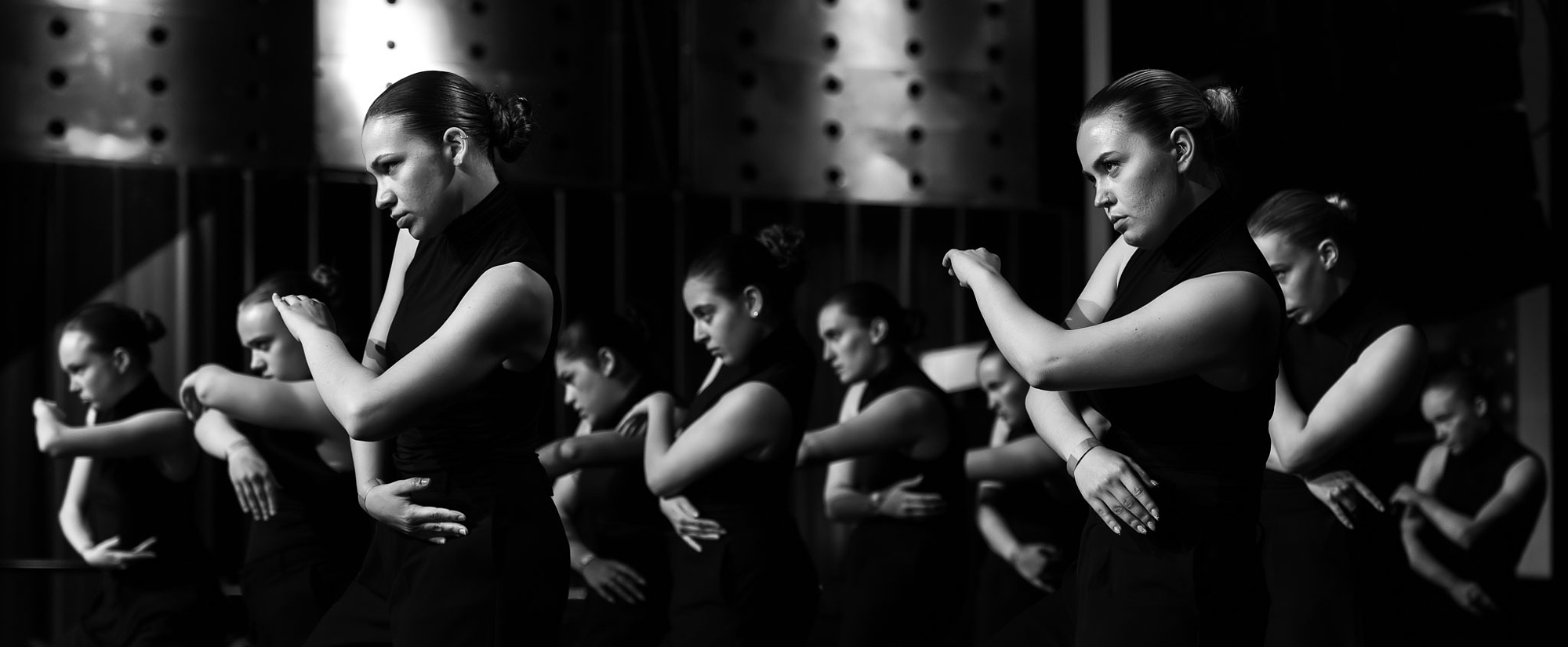 Row of dancers frozen mid-movement in black and white at World of Dance Eindhoven